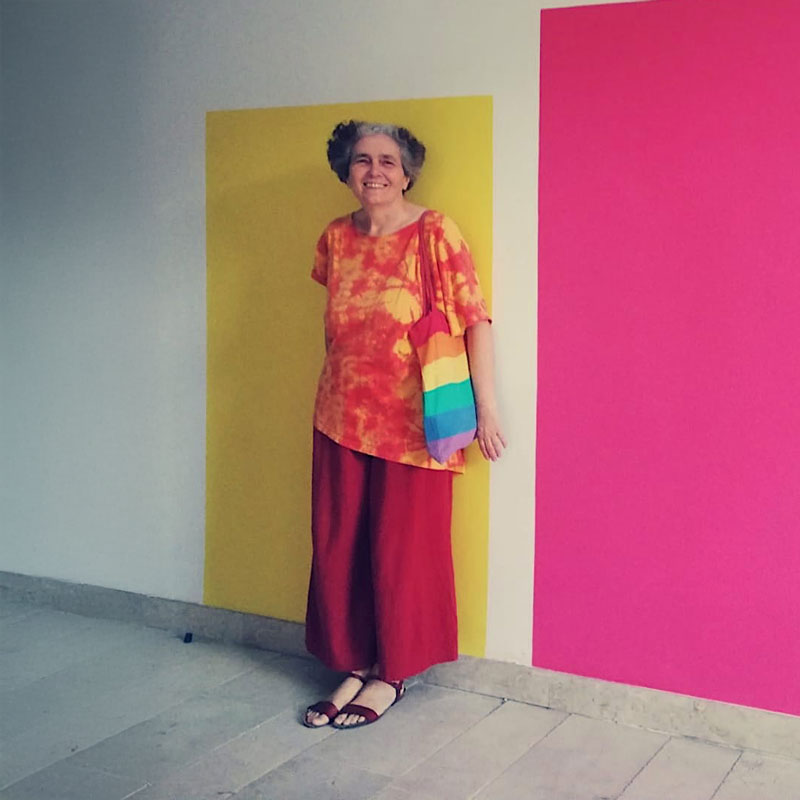 a woman standing in front of a colorful wall
