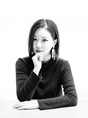 a black and white photo of a woman sitting at a table