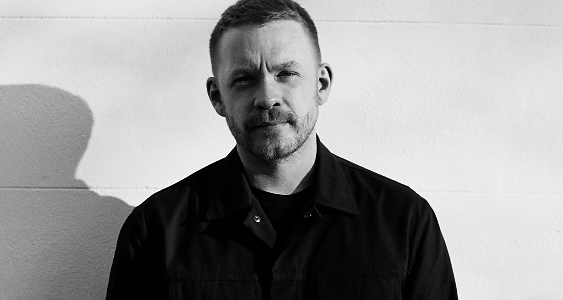 a man standing in front of a white wall