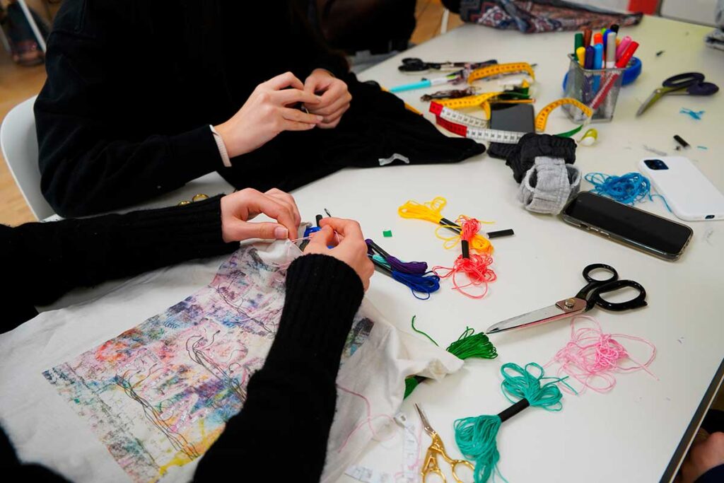 a group of people sitting at a table working on crafts