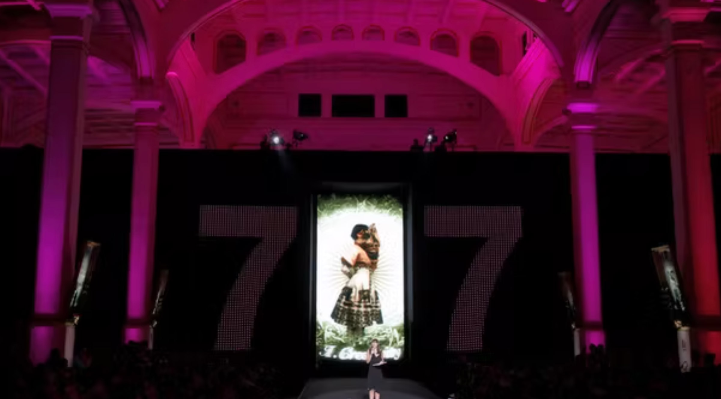 a woman is walking down the runway at a fashion show